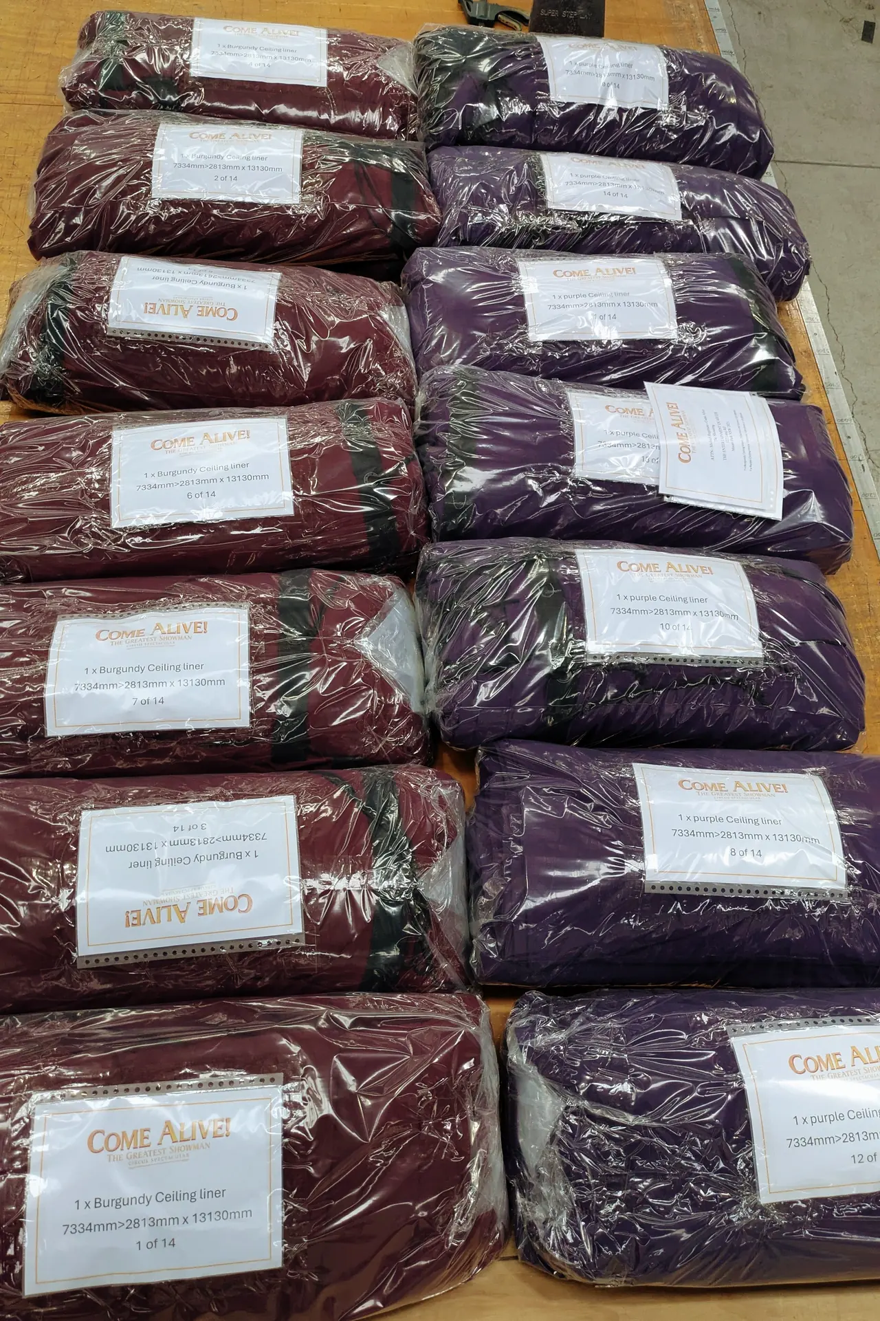 Burgundy and purple roof swags wrapped in clear film and labelled with colour, size and number in the set